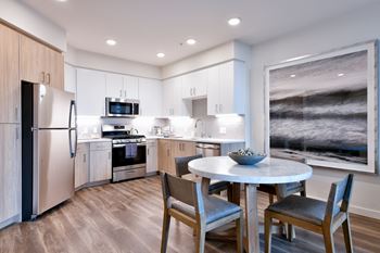 a kitchen with stainless steel appliances and a round table with chairs